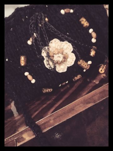 Para llevar sólo lo indispensable,  mini morral de algodón tejido a dos agujas.. con detalle de mostacillas y flor en hilo encerado